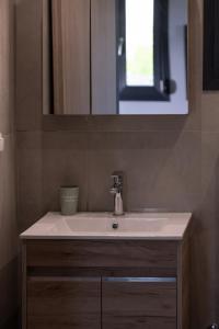 un baño con lavabo y espejo en Asteria Mare by Aetherion Studios & Suites, en Kalivia Poligirou 16 fotos más