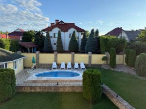 ein Garten mit Pool, Stühlen und einem Haus in der Unterkunft Aero Hotel in Chişinău
