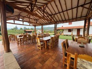 a restaurant with wooden tables and chairs on a patio at Hotel Palais Barichara in Barichara