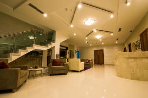 a lobby with couches and a staircase in a building at Hotel Parque Del Sol in Montería