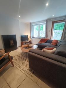 a living room with a couch and a table at Le cottage du renard, à côté de la Meuse Namur et Dinant in Namur