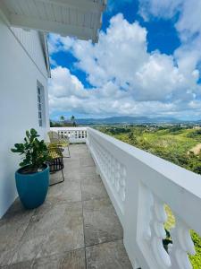 a white balcony with chairs and a potted plant at La Casita Blanca Chalet Incredible View Romantic in San Lorenzo +38 photos