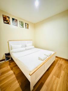 a large white bed in a room with wooden floors at Homestay Room near Kuta & Legian Beach Bali in Pesanggaran