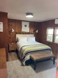 ein Schlafzimmer mit einem Bett und einer Bank darin in der Unterkunft Cape Cod Motor Inn in South Yarmouth