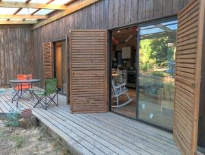 a wooden deck with a table and a patio at Cabaña Bosque Tumán in Pullingue