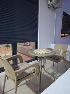 a table and chairs in a room with a window at Vhtwins apartment in Ulcinj
