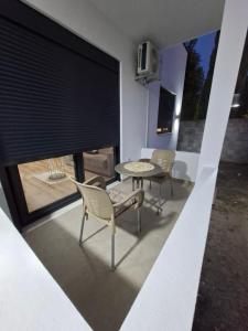 a patio with a table and chairs and a window at Vhtwins apartment in Ulcinj