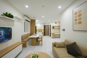 a living room with a couch and a table and a kitchen at VINHOMES GRAND PARK QUẬN 9 Căn hộ bnb 1pn in Gò Công