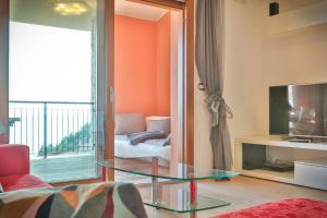 a living room with a glass table and a television at Portopiccolo Avolare Apartment InRed - beach included in Sistiana