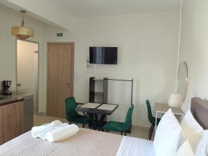 a room with a bed and a table and chairs at Euphoria City Homes in Argostoli