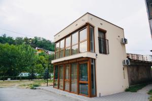 a white building with glass windows on a street at HANA Superior Apartment in Kakanj