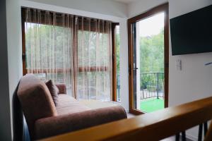 a living room with a couch and a large window at HANA Superior Apartment in Kakanj