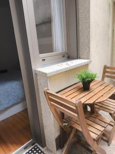 eine Holzbank und einen Tisch auf dem Balkon in der Unterkunft Apartamento Playa de Coroso in Ribeira