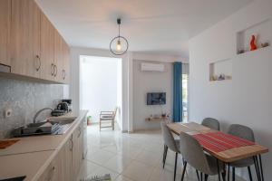 a kitchen with a table and a dining room at Mediterranean Apartments in Himare