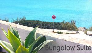 a stop sign and a plant in front of the ocean at Mandala Bungalows - Adults Only in Los Caños de Meca