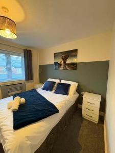 a bedroom with a large bed with a blue blanket at Spacious 3-Bed House - Sleeps 8 Garden & Parking in Peterborough