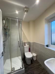 a bathroom with a shower and a toilet and a sink at Spacious 3-Bed House - Sleeps 8 Garden & Parking in Peterborough