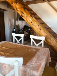 a kitchen with a table and two white chairs at La Joaquina, Casa de montaña. in El Chalten