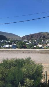 an empty road with houses and mountains in the background at La Joaquina, Casa de montaña. in El Chalten +24 photos