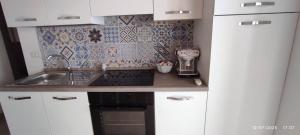 a small kitchen with white cabinets and a sink at Casa Sofia in Condrò