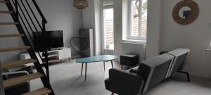 a living room with a chair and a table and a television at Maison 3 chambres avec jardin Gien in Gien