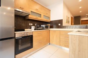 Una cocina con gabinetes de madera y un horno de estufa. en Modern&quiet twin room with shared bathroom, en Sliema 4 fotos más