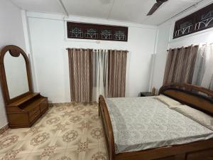 une chambre avec un lit et un miroir dans l'établissement Maadhuban Home Stay, à Dibrugarh