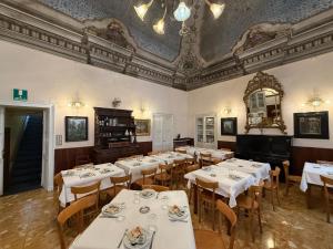 Pieve di TecoAlbergo Dellangelo的餐厅设有白色的桌椅和天花板