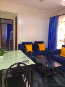 a living room with a blue couch and a table at Cozyblue fully furnished 1 bedroom bnb in Mombasa