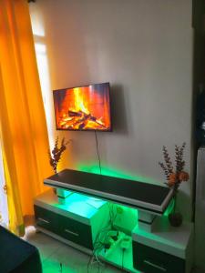 a living room with a television on a wall at Cozyblue fully furnished 1 bedroom bnb in Mombasa