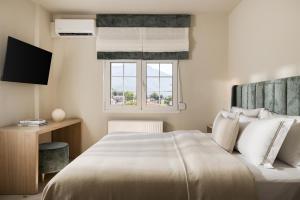 a bedroom with a large bed and a window at Meteoron Suites in Kalabaka