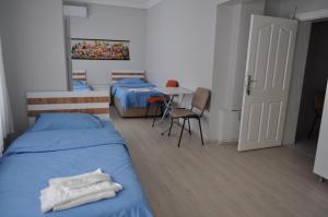 a bedroom with two beds and a table with a chair at BULUT GAYE Pansiyon in Edirne