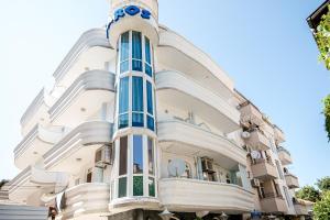 a large white building with blue windows at Family Hotel Paros 2 in Pomorie