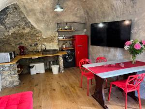 a kitchen with a table and a red refrigerator at Acquaviva, Petra - By Ligooria in Tovo San Giacomo