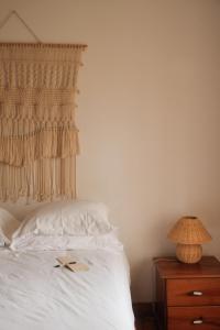 a bed with a cross on it with a lamp on a night stand at Quinta Amarela - B&B in Nazaré
