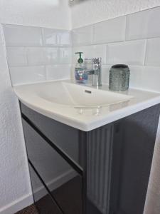 a white sink in a bathroom with white tiles at Firthview House in Kirn +76 photos