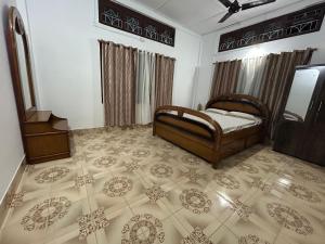 une chambre avec un lit et un sol carrelé dans l'établissement Maadhuban Home Stay, à Dibrugarh