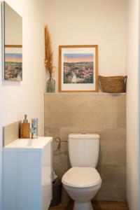 a bathroom with a white toilet and a sink at Maison de campagne avec salle de jeux 6 personnes in Cuq +50 photos