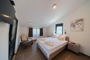 a bedroom with a bed and a chair in it at Villa Goranovic in Herceg-Novi