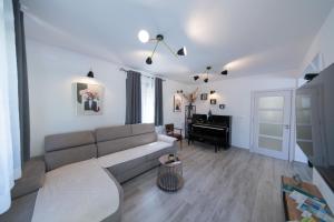 a living room with a couch and a piano at Villa Goranovic in Herceg-Novi