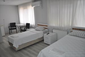 a bedroom with two beds and a table and chairs at BULUT GAYE Pansiyon in Edirne +15 photos