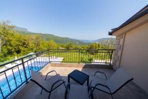 a balcony with chairs and a view of a pool at Villa Goranovic in Herceg-Novi
