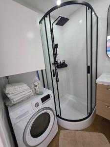a bathroom with a shower and a washing machine at Bel appartement avec vue mer in Le Trayas +41 photos
