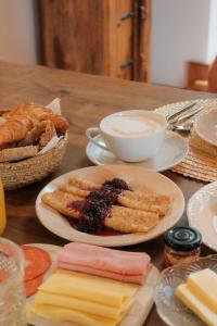 a wooden table topped with plates of food and bread at Quinta Amarela - B&B in Nazaré