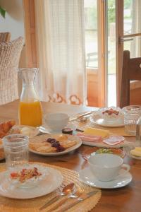 a table with plates of food and a jug of orange juice at Quinta Amarela - B&B in Nazaré