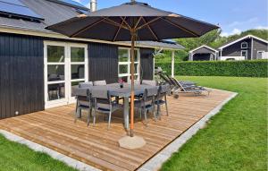 una terrazza in legno con tavolo e ombrellone di Holiday Home Barsbæklund Aabenraa V a Loddenhøj