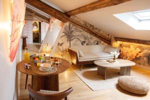 un salon avec un canapé et une table dans l'établissement CEVA Suite Sakura - Jacuzzi & Cinéma Centre ville, à Saint-Étienne