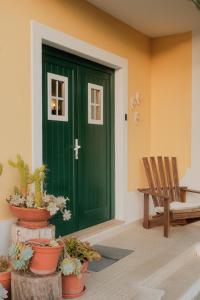a green door with a bench and potted plants at Quinta Amarela - B&B in Nazaré