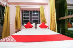 a bedroom with a large bed with red pillows at Collection O NEOSTAY TOWN HOUSE in Kolkata