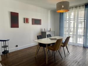 a dining room with a table and chairs at Appartement Le Temple Auxerre Centre Ville in Auxerre